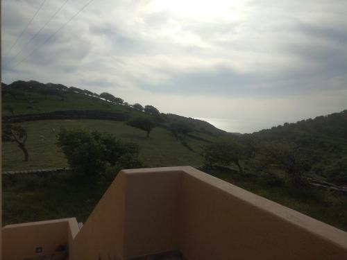 a view of a green hill from a balcony at Αγ Νικόλαος Karthaia in Elliniká