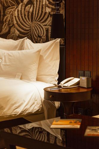 a bedroom with a bed and a table with a phone at Country Club Lima Hotel – The Leading Hotels of the World in Lima