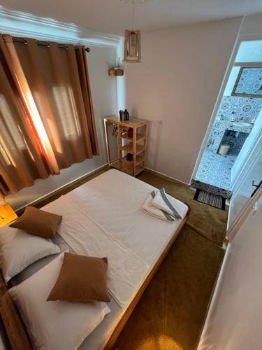a bedroom with a bed and a window at Dar Surf in Taghazout
