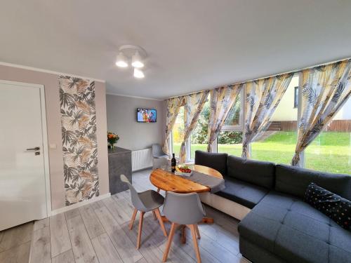 a living room with a couch and a table at Domek pod świerkami in Kudowa-Zdrój