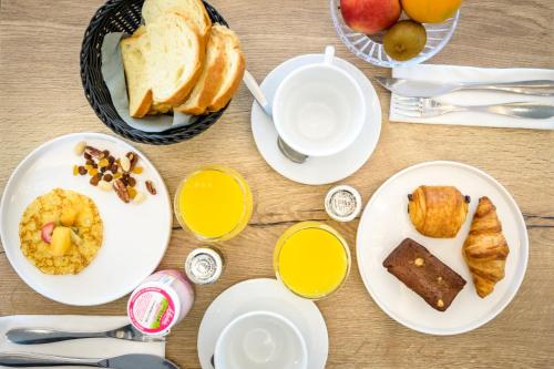 a table with plates of breakfast food on it at Hôtel Le Martray in Ars-en-Ré