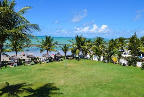 a view of a beach with palm trees and the ocean at O paraíso em um flat à beira-mar de Carneiros in Tamandaré