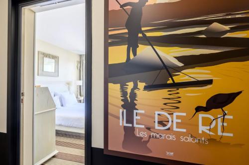 a poster of a man on a boat in a room at Hôtel Le Martray in Ars-en-Ré