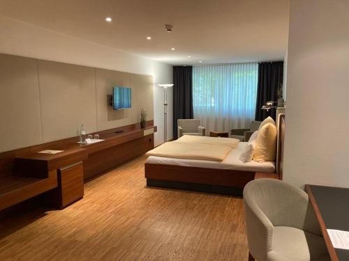 sypialnia z łóżkiem, biurkiem i umywalką w obiekcie Gästehaus an der Oase w mieście Versmold
