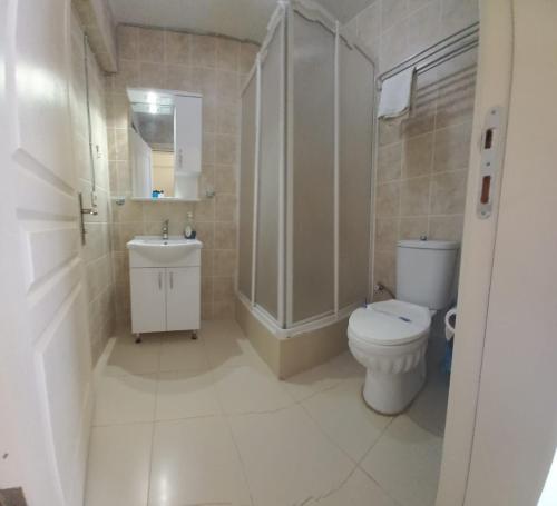 a bathroom with a toilet and a shower and a sink at Hotel Antonio in Çeşme