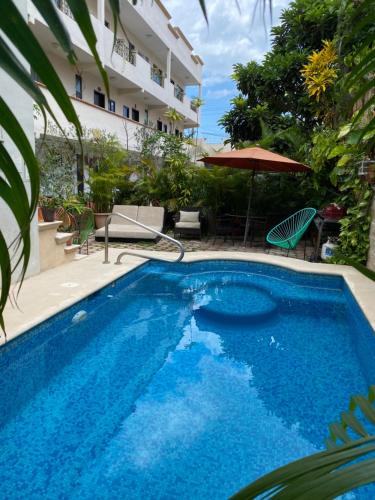 a large blue swimming pool next to a building at Suites Fenicia in Playa del Carmen
