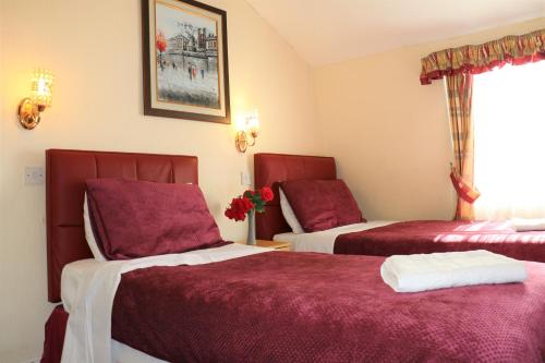 a hotel room with two beds with red covers at Barry House in London