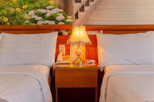 um quarto com 2 camas e um candeeiro numa mesa de cabeceira em Giang Linh Hotel em Ho Chi Minh