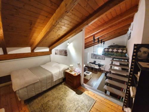 un dormitorio en el ático con una cama y una escalera en Maison Di Gugli, en Brandizzo