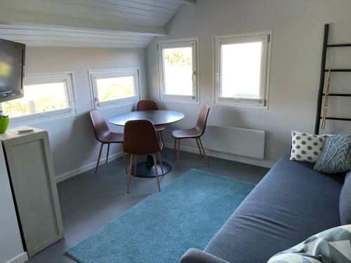 a living room with a couch and a table and windows at Blokhut Klein Meerzicht in Haren
