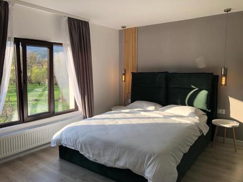 sypialnia z dużym łóżkiem i dużym oknem w obiekcie RDT Guest House-Rai din Transilvania w mieście Moieciu de Jos