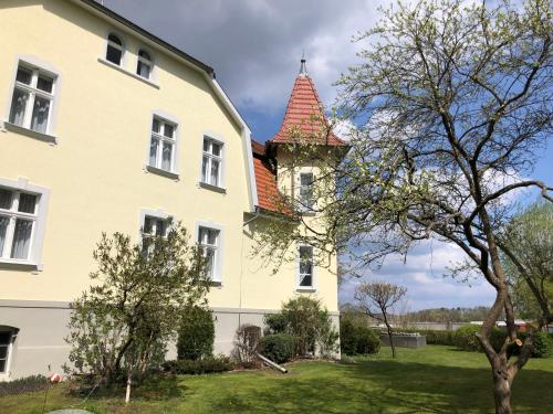 ein großes weißes Haus mit rotem Dach in der Unterkunft Gast-& Logierhaus Am Rheinsberger See in Rheinsberg