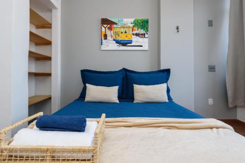 1 dormitorio con 1 cama con sábanas azules y almohadas blancas en Omar do Rio: Completo Qto&Sala, Internet 250mbps, Smart TV, Canais a cabo e a 3 minutos caminando da Praia de Copacabana (NSC 115/1403), en Río de Janeiro