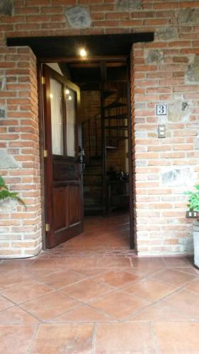 安地瓜的住宿－Casita Acogedora，木门砖砌建筑的入口