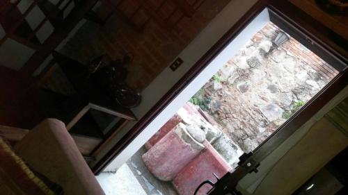 安地瓜的住宿－Casita Acogedora，开放式门,享有砖墙的景色