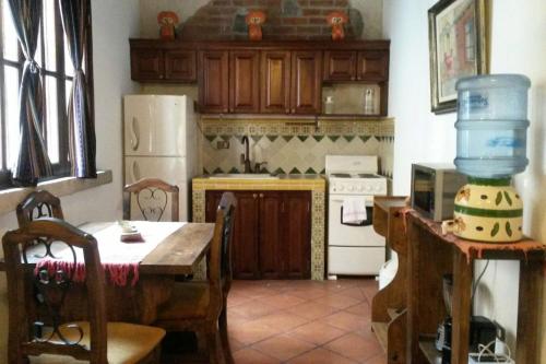 a kitchen with a table and a white refrigerator at Casita Acogedora in Antigua Guatemala