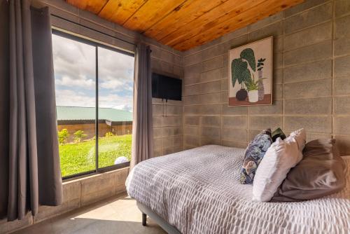 a bedroom with a bed and a large window at Espectacular Cabaña Moderna de Montaña + Bosque Nuboso +Wifi in Zarcero
