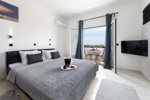 a bedroom with a bed with a plate of food on it at Anna Anton Apartment in Kolymbia