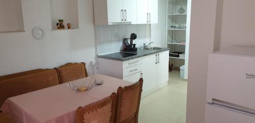 a kitchen with a table with a pink table cloth at Apartman Djekovic in Jošanička Banja