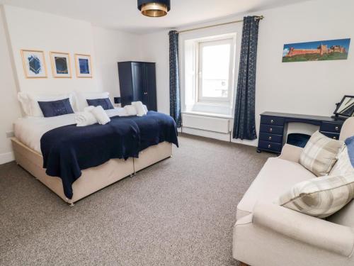 a bedroom with a bed and a couch at The Old Sweet Shop in Alnwick