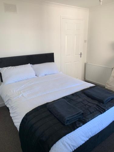 a large bed with two pillows on top of it at Dumfries Apartment in Dumfries