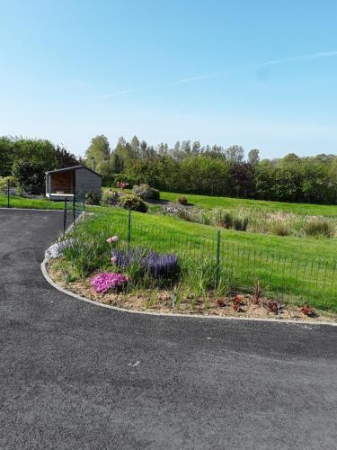 a garden with flowers on the side of a road at Chambres d'hôtes de L'orval in Thiergeville