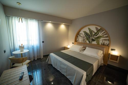 - une chambre avec un lit, une table et une fenêtre dans l'établissement Ingrid Rooms Tropea, à Tropea