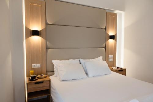 a bedroom with a large white bed with two pillows at HOTEL_TIER in Athens
