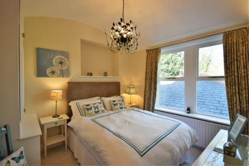 a bedroom with a bed and a window and a chandelier at The Vault at Westacres in Hexham