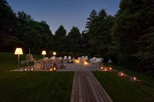 a patio with tables and chairs and lights at night at Relais & Châteaux Hardenberg BurgHotel in Nörten-Hardenberg