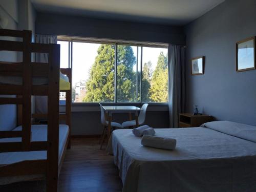 a bedroom with two beds and a large window at Center Vistas in San Carlos de Bariloche