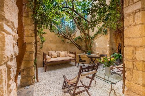 a patio with a couch and a table and chairs at Hotel Boutique V in Vejer de la Frontera