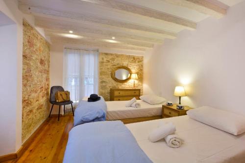 a bedroom with two beds and a mirror at CASA LIBRETTO OLD TOWN CORFU in Corfu