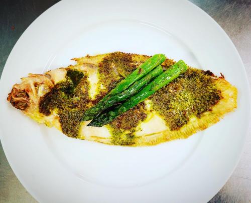 a white plate with a piece of food with asparagus at St Tudy Inn in Bodmin