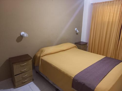 a small bedroom with a bed and a night stand at San Remo World Hotel in San Clemente del Tuyú