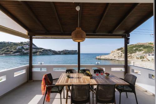 una mesa en un balcón con vistas al océano en Beach front apartment with swimming pool, en Ligaria