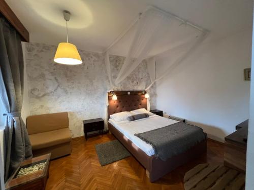 a bedroom with a king sized bed and a couch at Guest house Mediterranea in Pakoštane