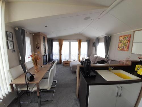 a living room with a kitchen and a living room with a couch at The Meadows New Beach Holiday Park in Kent
