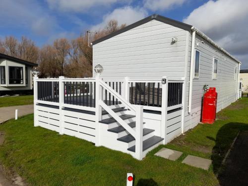 a white building with a gate and a fire hydrant at The Meadows New Beach Holiday Park in Kent