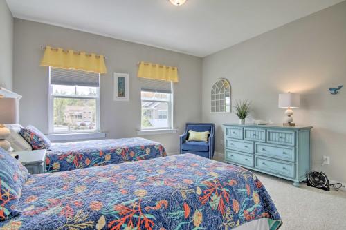 a bedroom with two beds and a dresser and two windows at 2 Mi to Bethany Beach Modern Townhome with Patio in Ocean View