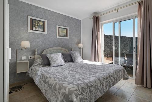 a bedroom with a bed and a large window at Villa Fae in Playa Blanca