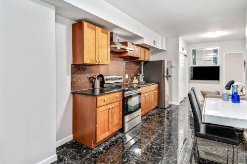 a kitchen with wooden cabinets and a living room at Cozy 1BD steps away from Convention Center in Philadelphia