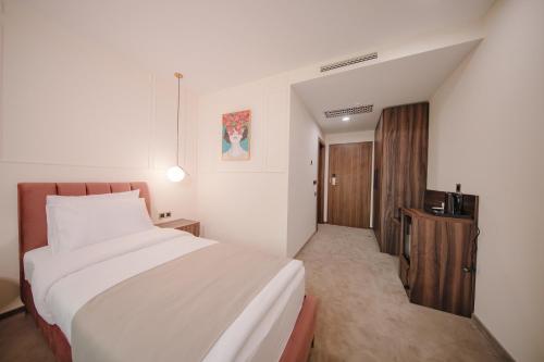a hotel room with a bed and a television at Orden Hotel in Tbilisi City