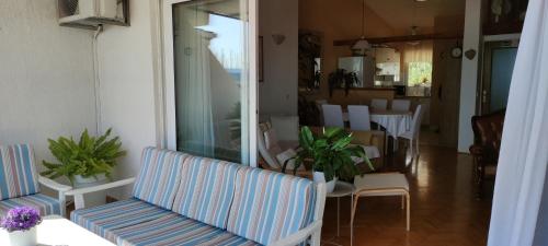 a porch with a couch and a table and chairs at Apartment Gallery in Kaštela