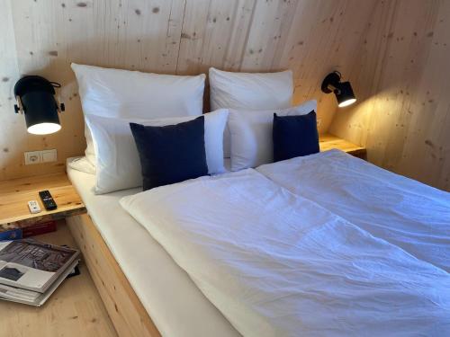 ein großes Bett mit weißer Bettwäsche und blauen Kissen in der Unterkunft Stadlnest Moser in Neustift im Stubaital