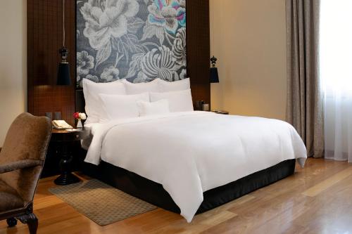 a bedroom with a large white bed and a chair at Country Club Lima Hotel – The Leading Hotels of the World in Lima