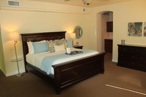 a bedroom with a bed with blue pillows and a dresser at Inn Above Oak Creek Sedona in Sedona