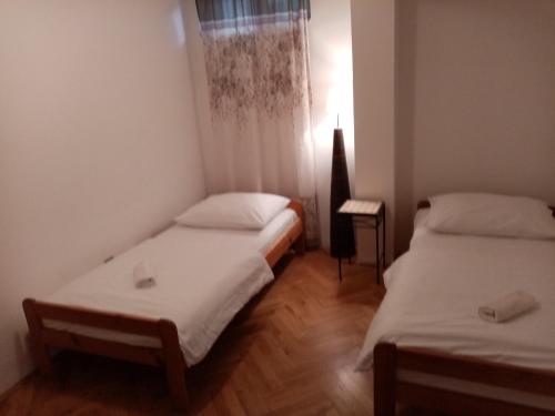 two beds in a small room with a window at Summerhouse Duće Omiš in Duće