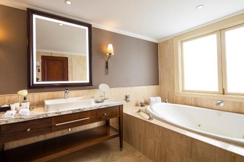 a bathroom with a large tub and a large mirror at Country Club Lima Hotel – The Leading Hotels of the World in Lima