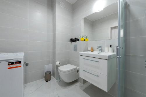 a white bathroom with a toilet and a shower at Luxury in City -3- Studio Bright & Secure Free Parking in Łódź